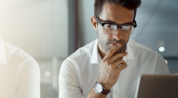 An investment advisor reviews cybersecurity tips on a laptop.